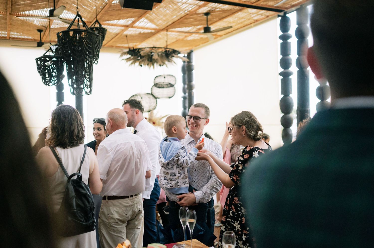 Crowd gathered at an indoor venue with wooden ceiling and ambient lighting.