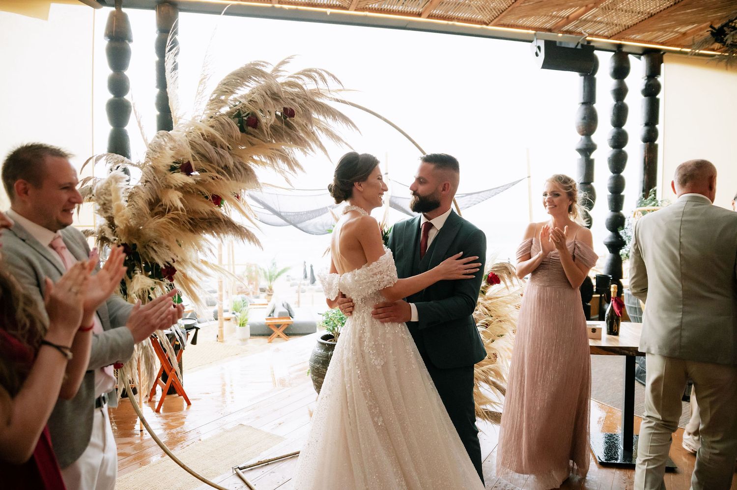 Wedding celebration in a bright venue with decorative hanging elements and natural light.