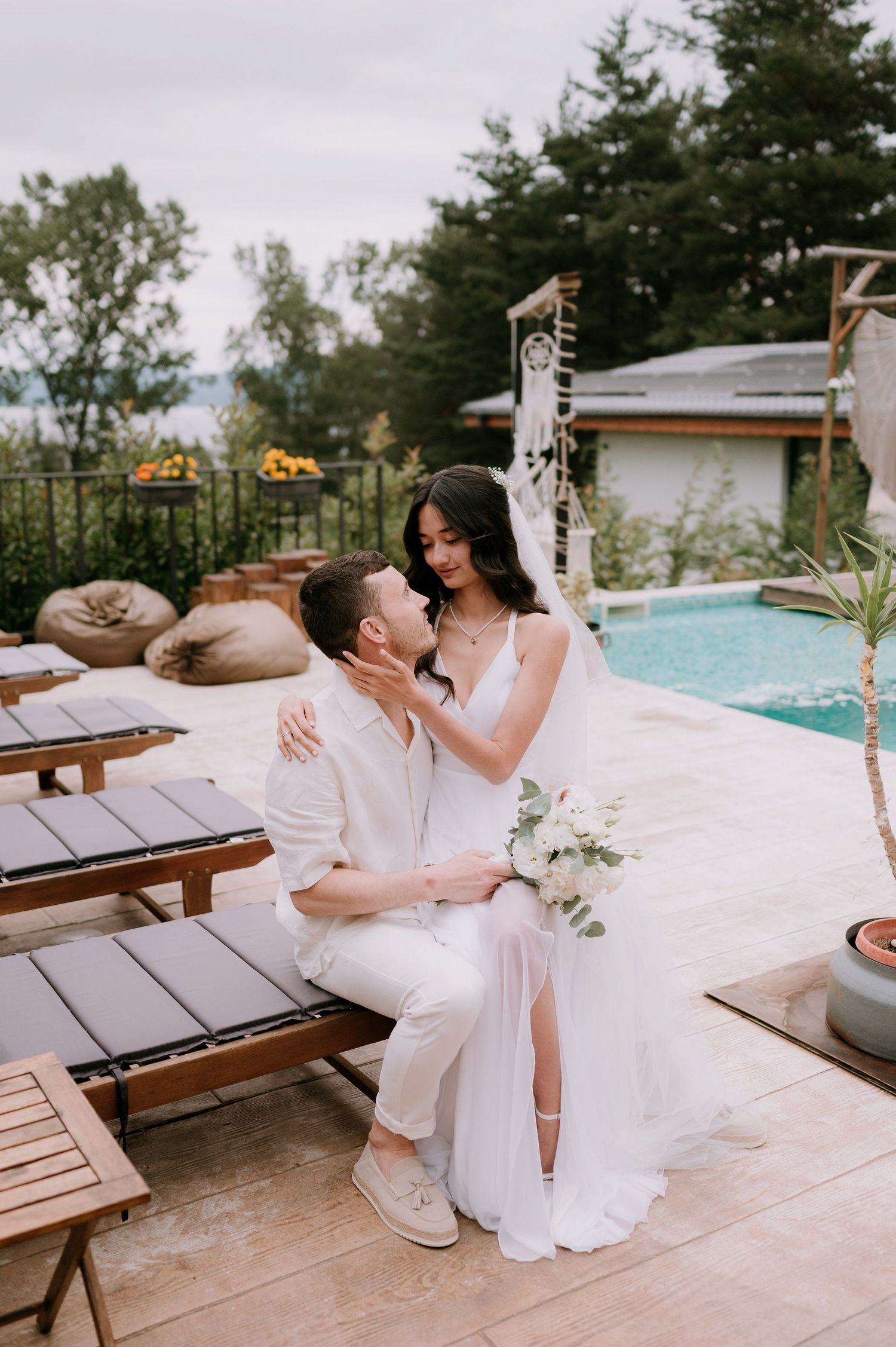 Candid wedding moments captured poolside with couple in coordinated white attire.