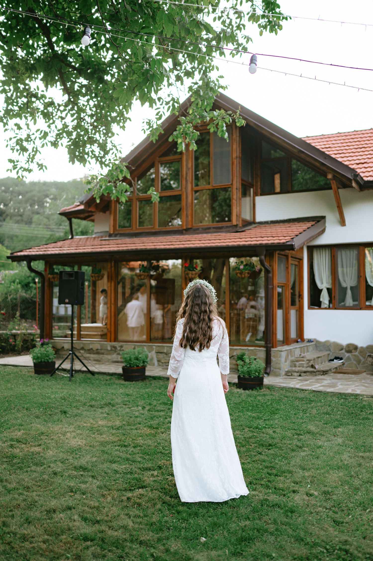 A flowing white wedding dress captured against a rustic wooden lodge backdrop.