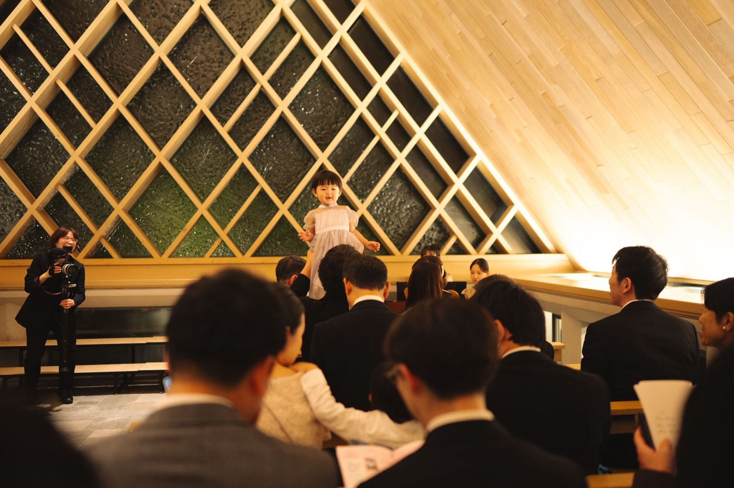 Performance or presentation taking place on stage with distinctive lattice backdrop.