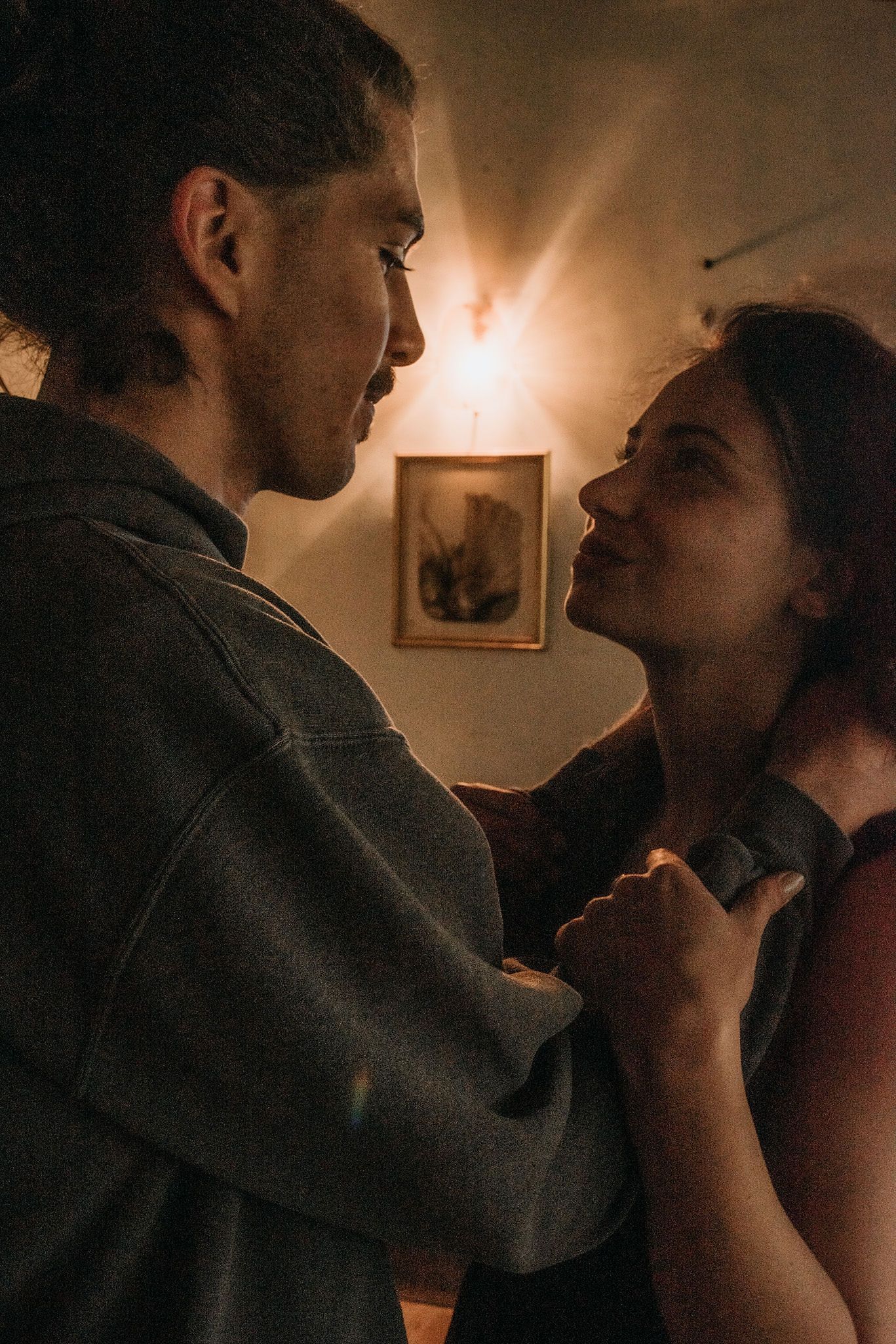 A romantic sequence of dimly lit intimate moments between a couple in a cozy indoor setting.
