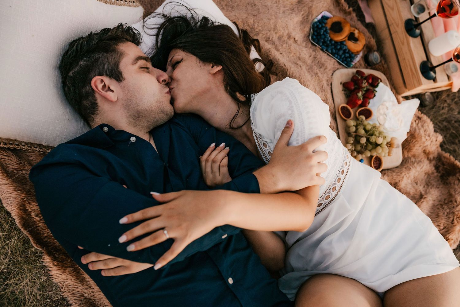 Intimate moment captured between couple on soft textured surface.