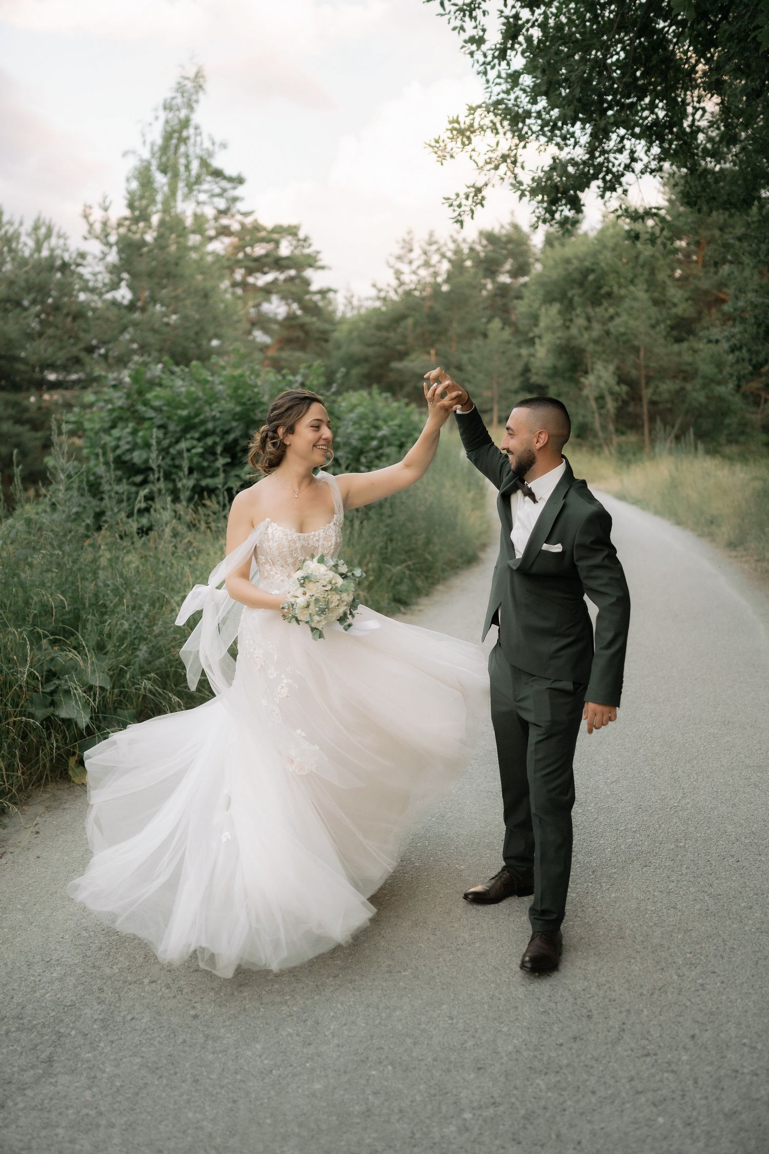 A romantic wedding dance sequence showing a couple twirling together on a tree-lined path.