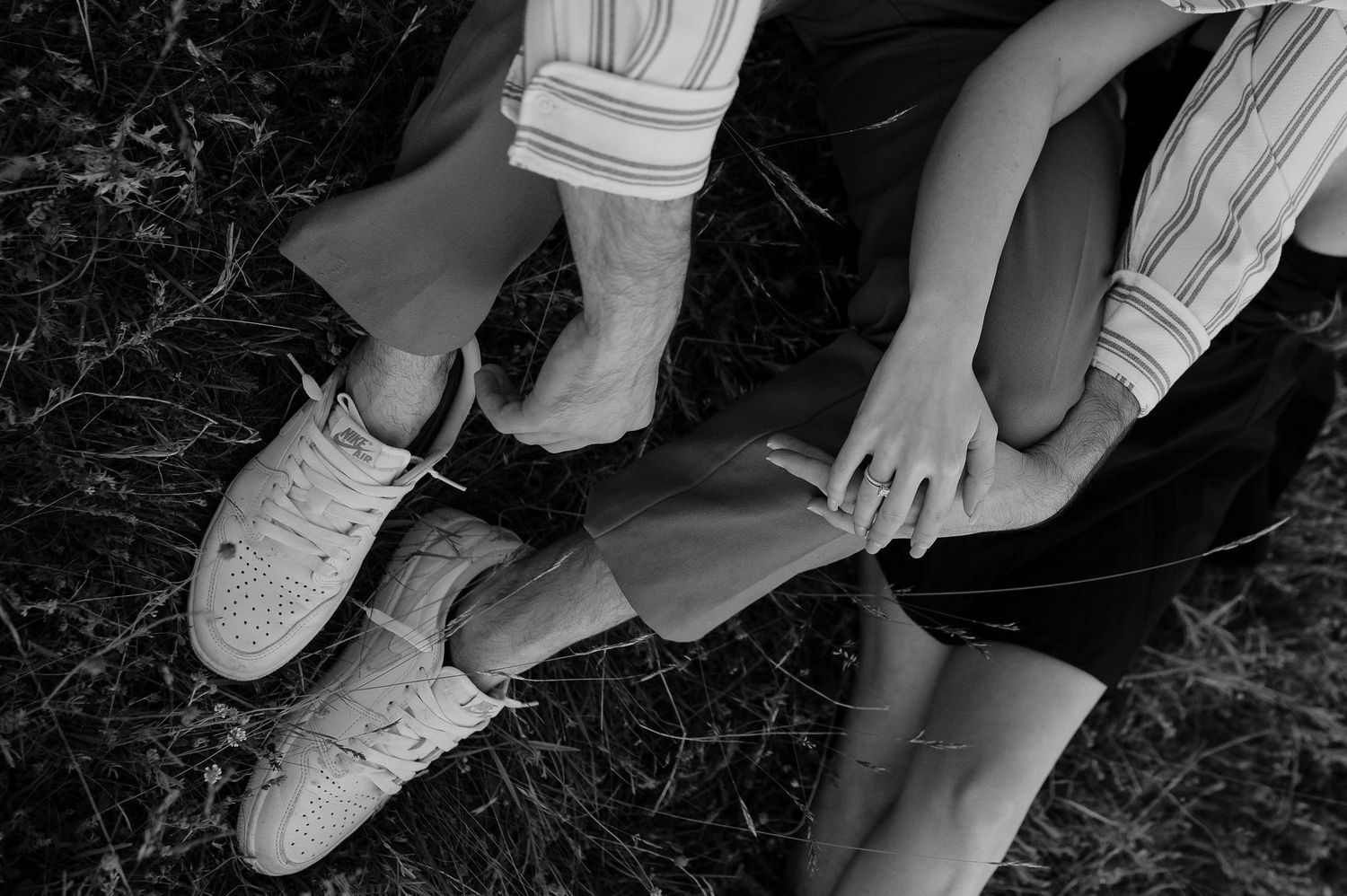 Close-up view of white sneakers on feet walking across a dark marble floor surface.