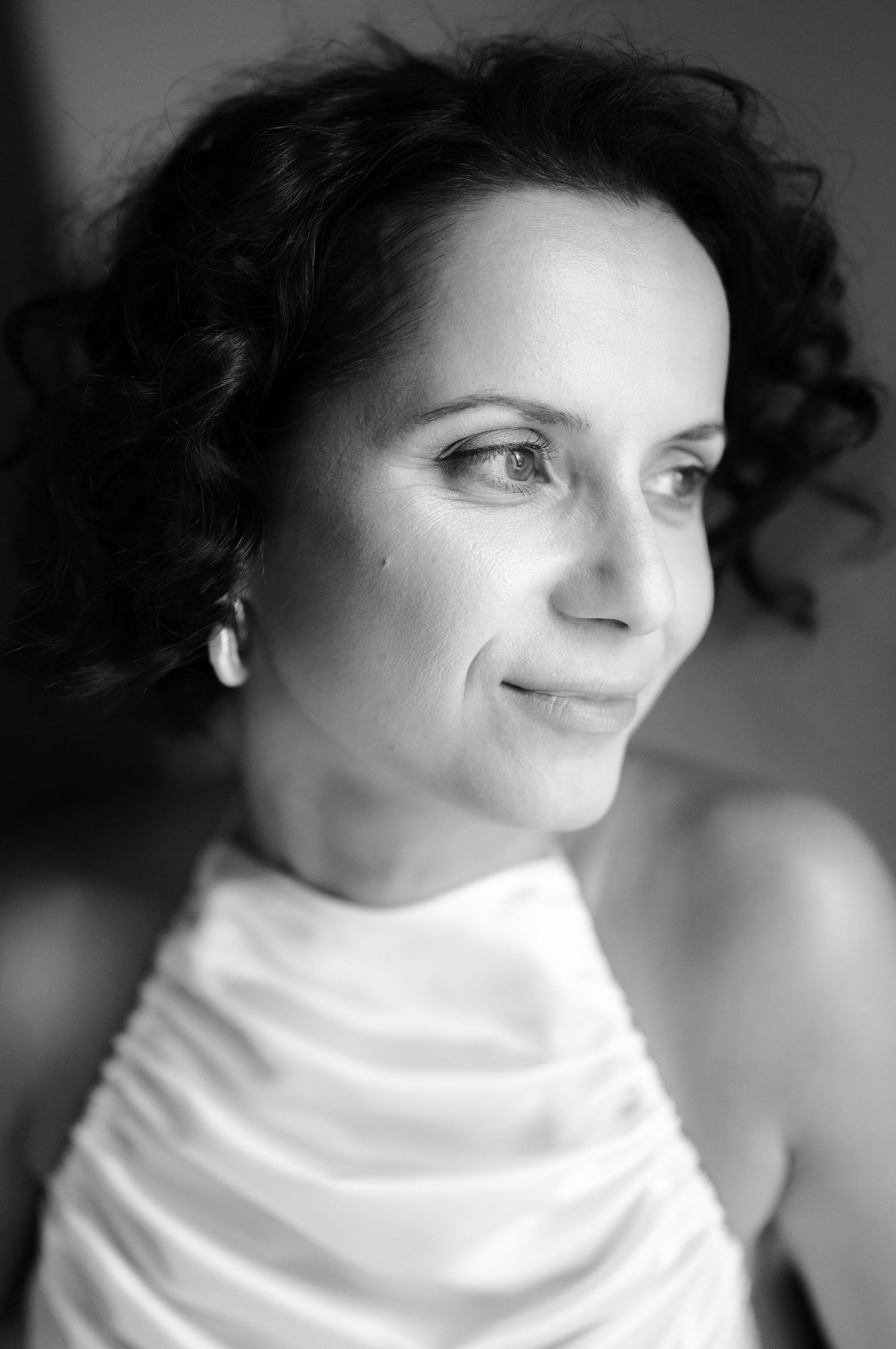 A series of black and white portraits showing someone wearing a white turtleneck sweater in different poses.
