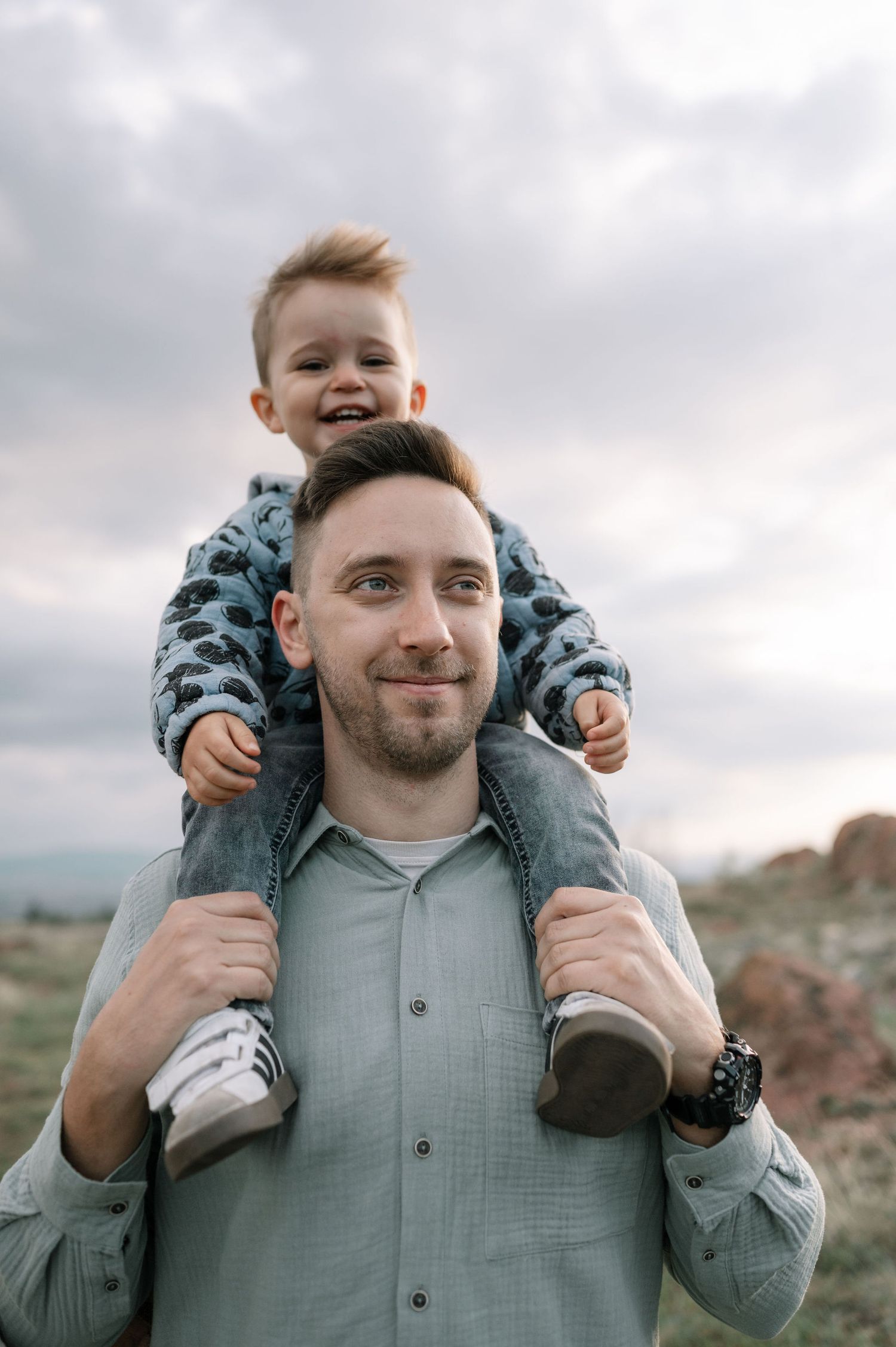 A series of candid outdoor photos showing a parent and child sharing joyful moments together against a cloudy sky.