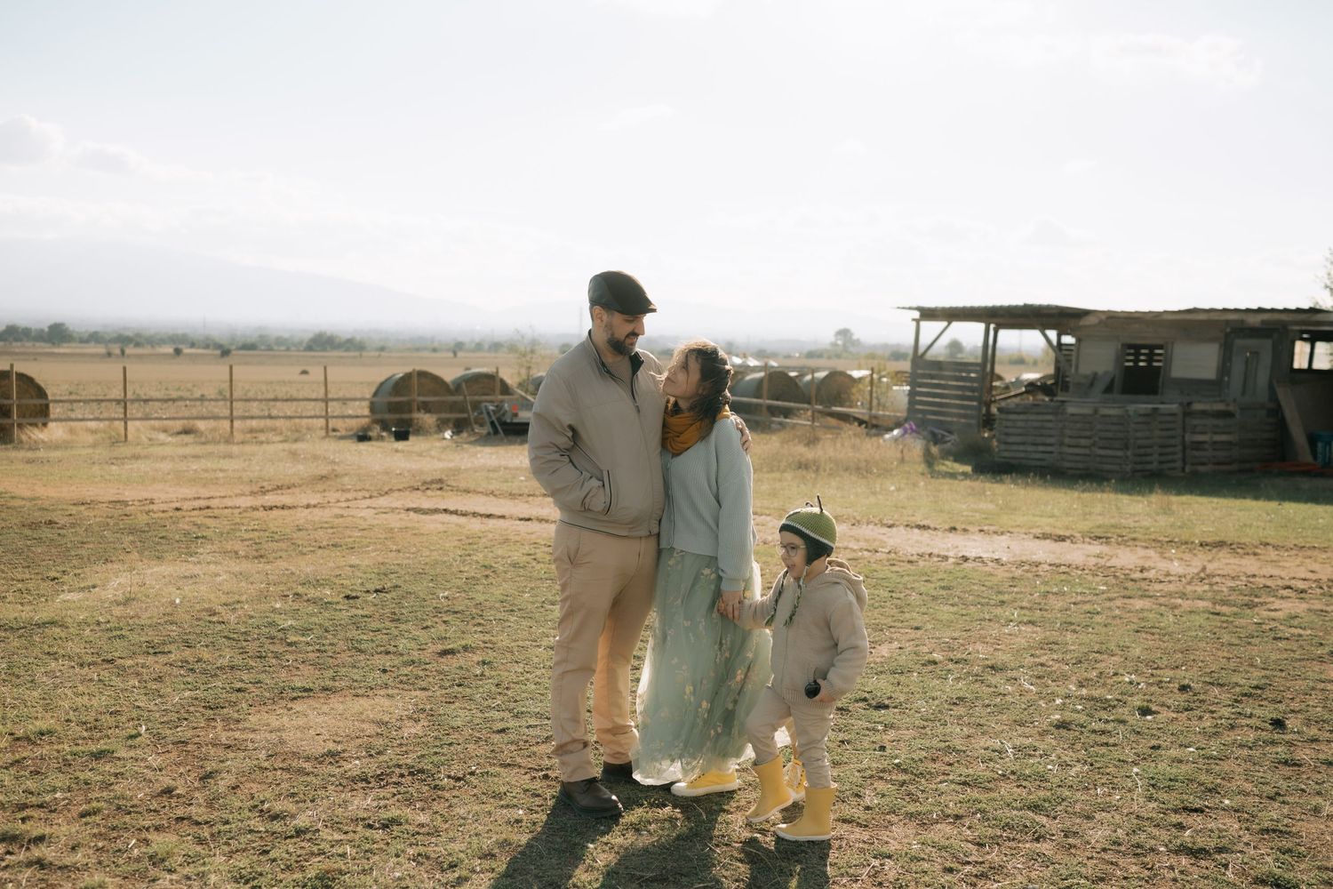 Farmers work in dry agricultural fields during drought conditions in a rural landscape.