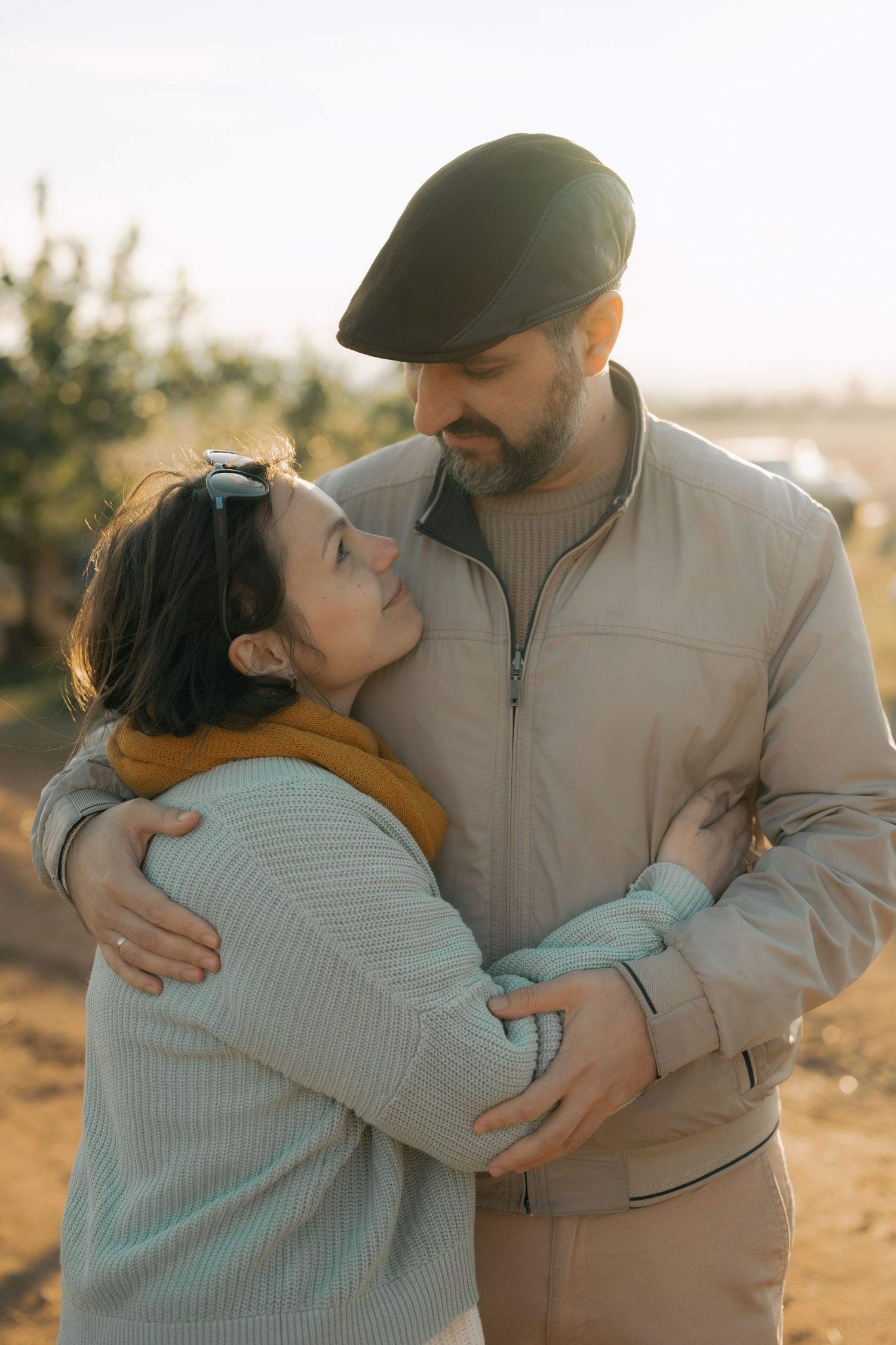 A couple shares tender moments in a series of romantic sunset photos while wearing casual attire.