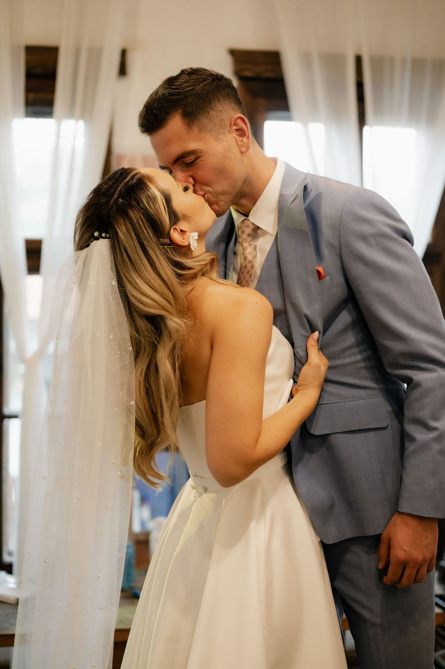 Romantic first look sequence between newlyweds sharing intimate moments in a rustic indoor setting.