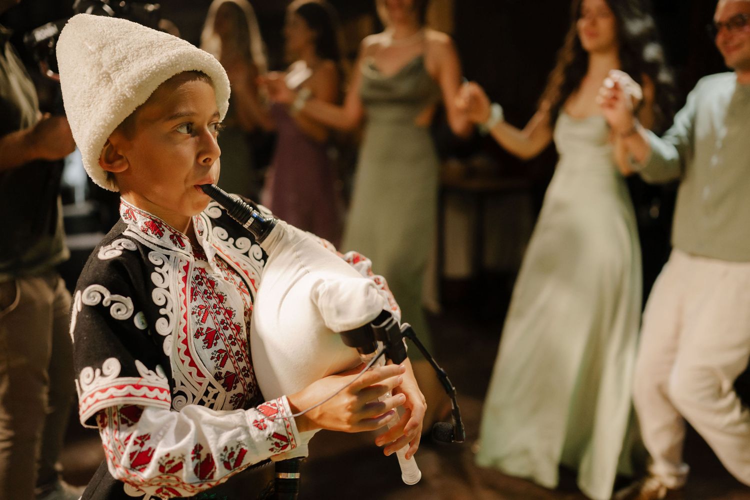 People dancing together in a traditional folk dance formation at a celebration event.