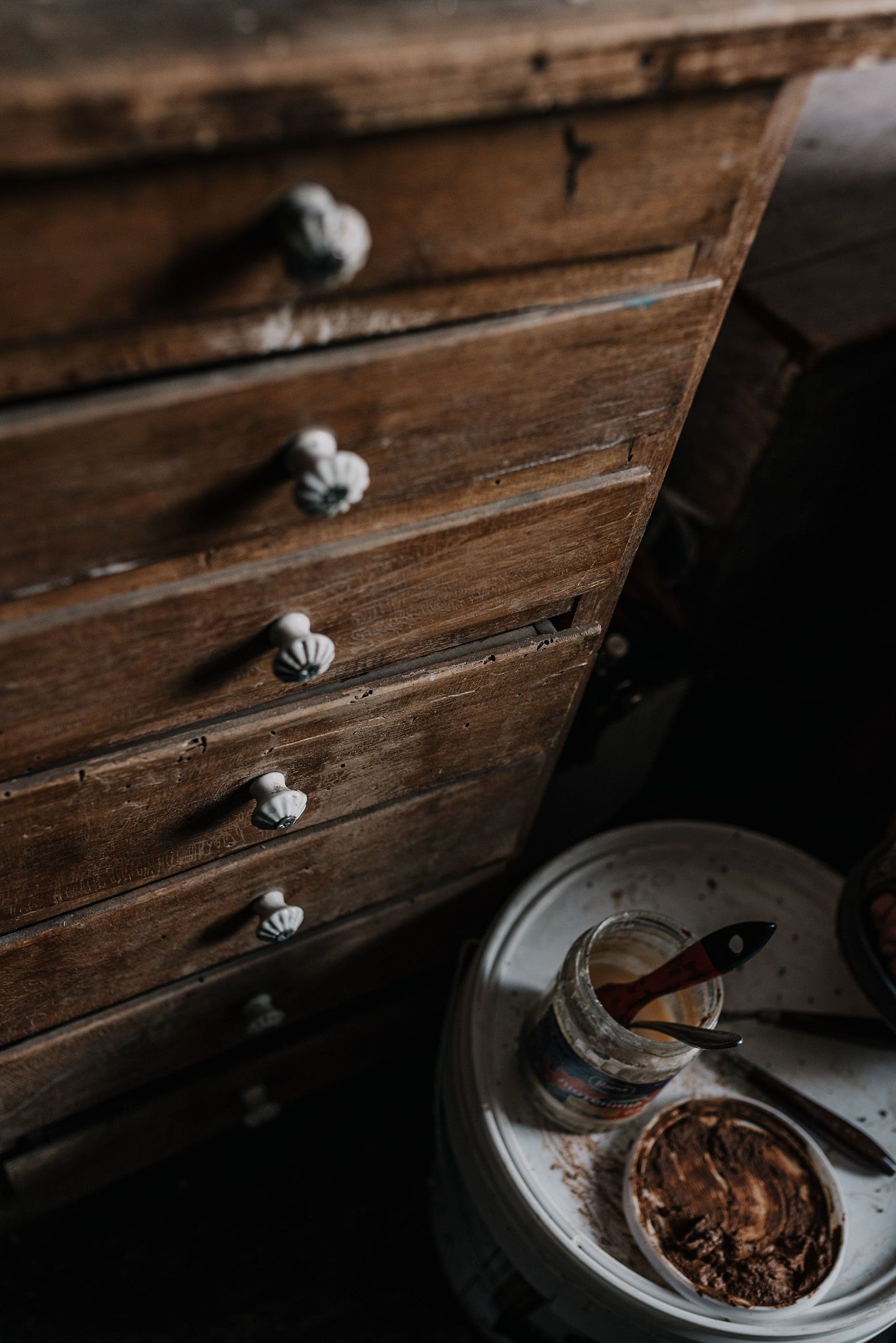 Vintage wooden drawer with antique knobs and dark shadows.