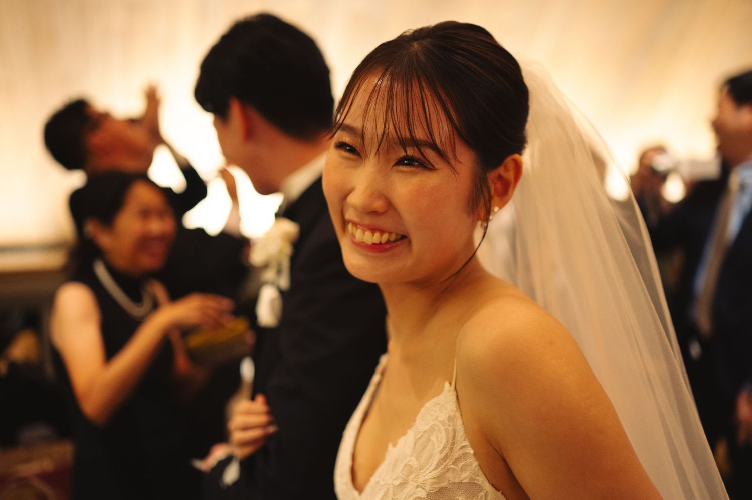 A joyful wedding reception moment captured in warm lighting.