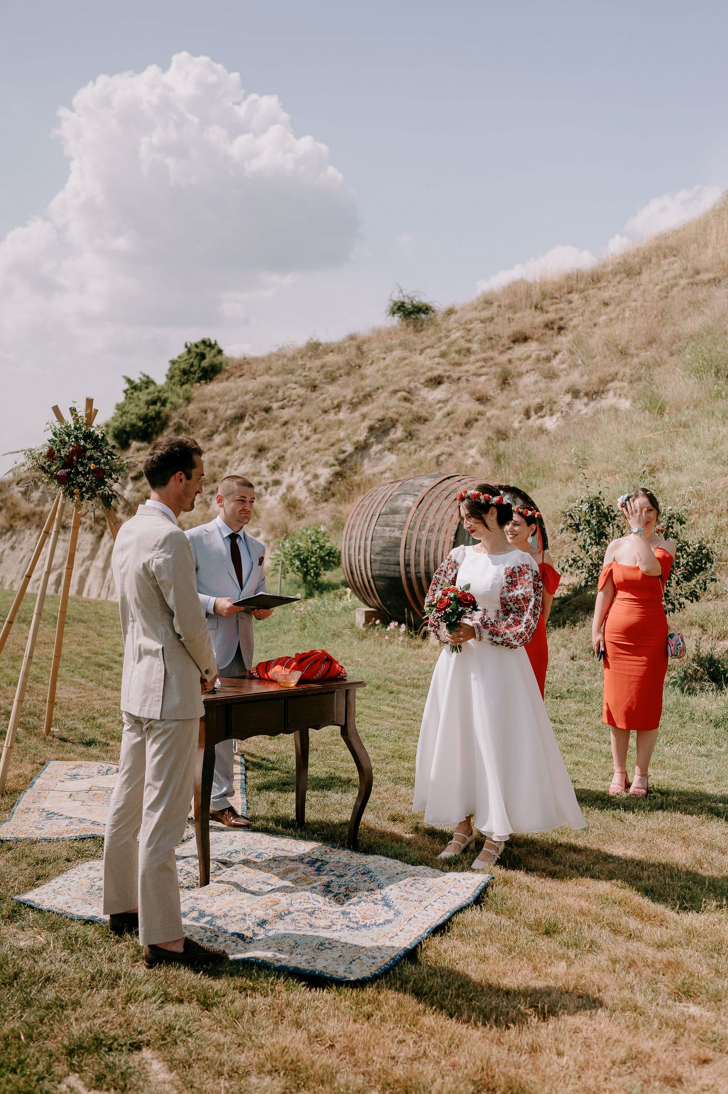 Intimate outdoor wedding ceremony with vintage decor and floral arrangements on a scenic hilltop.