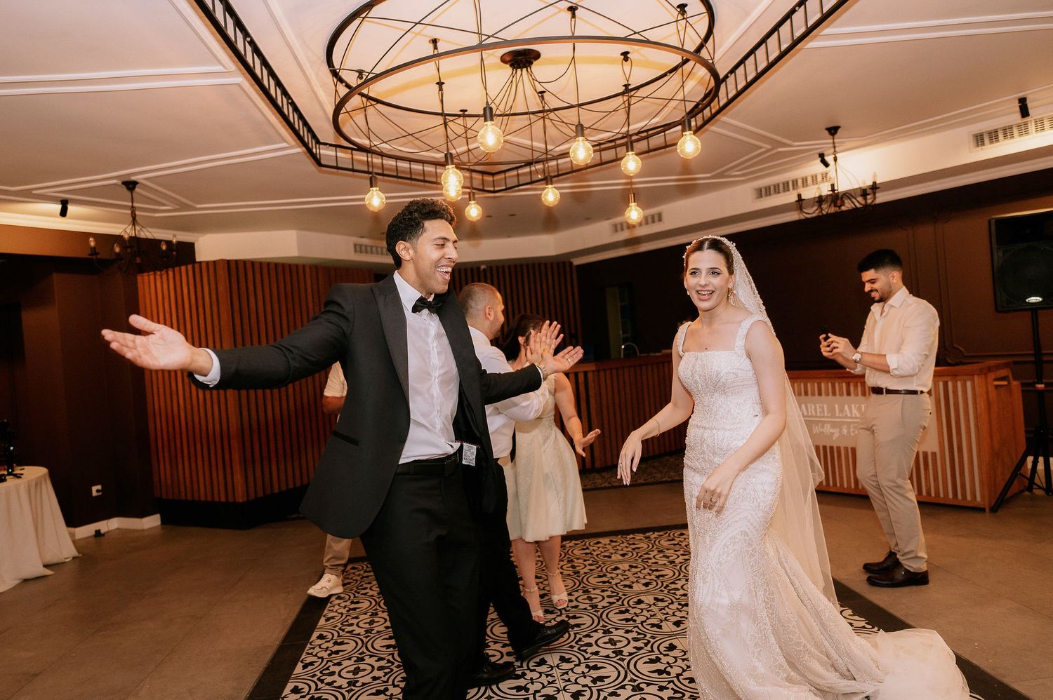 Celebratory dance moves being performed by guests at an indoor reception.