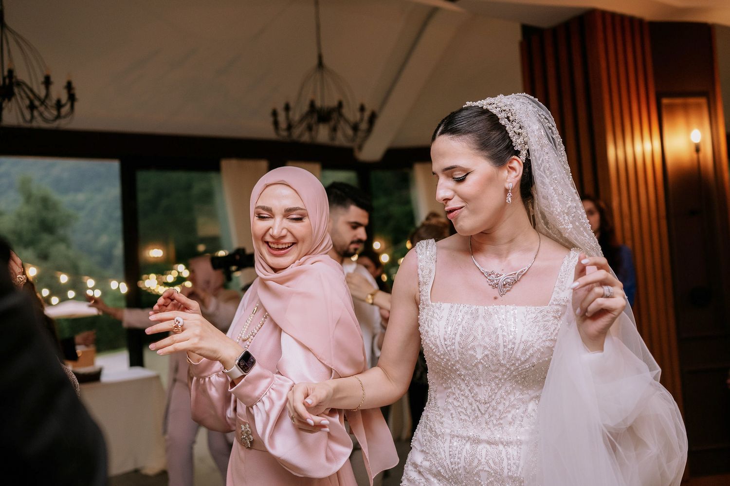 Wedding celebration with guests dancing in a beautifully decorated indoor venue.