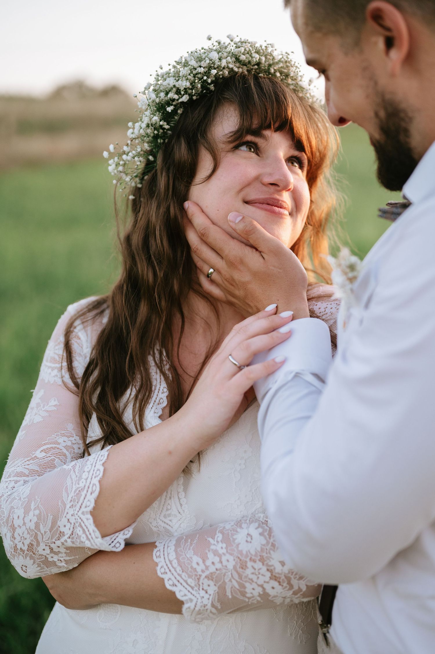 Intimate wedding portrait of couple sharing tender moments in a lace dress and white shirt.