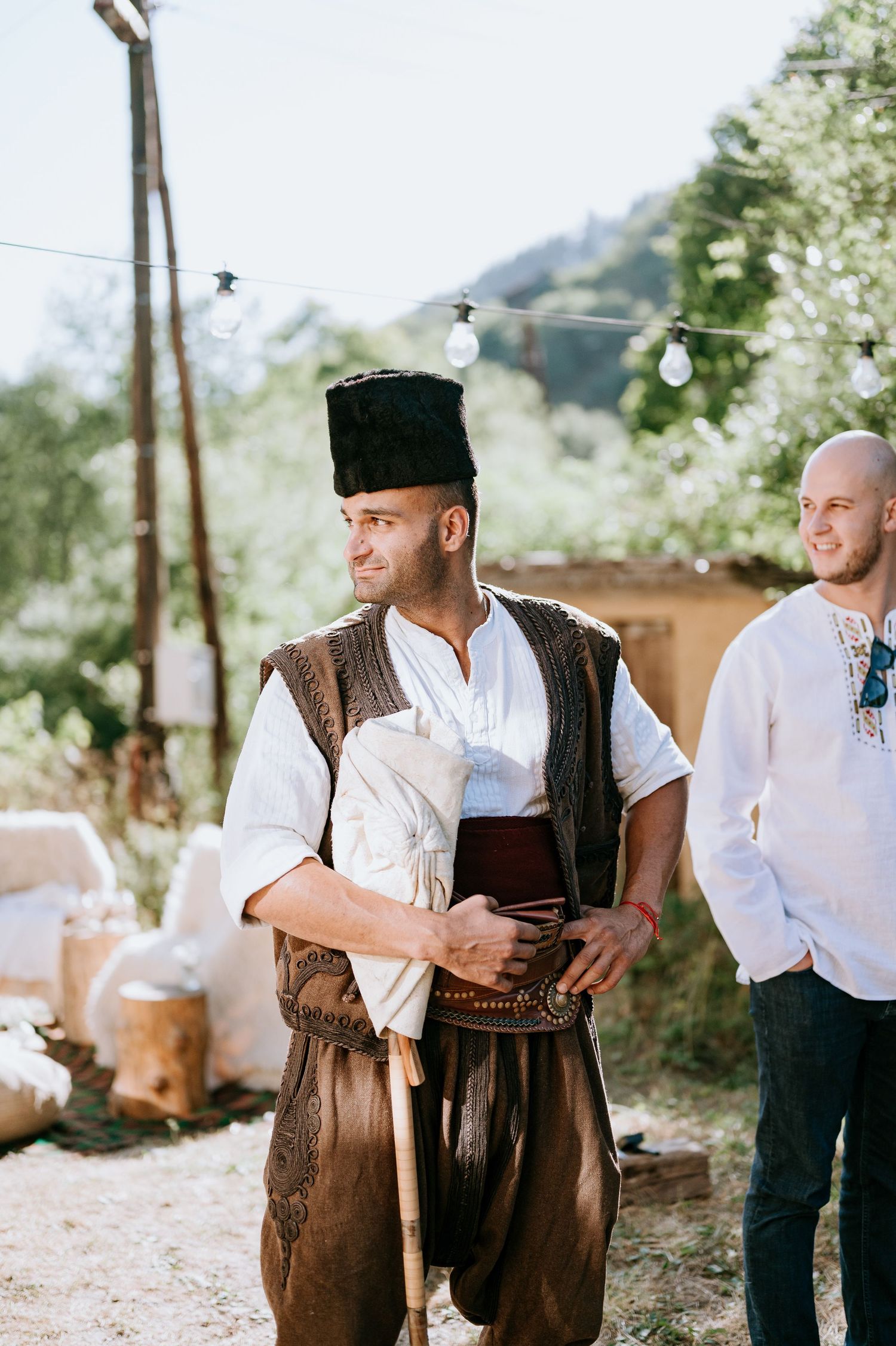 Wedding guests in traditional Bavarian attire gathering outdoors.