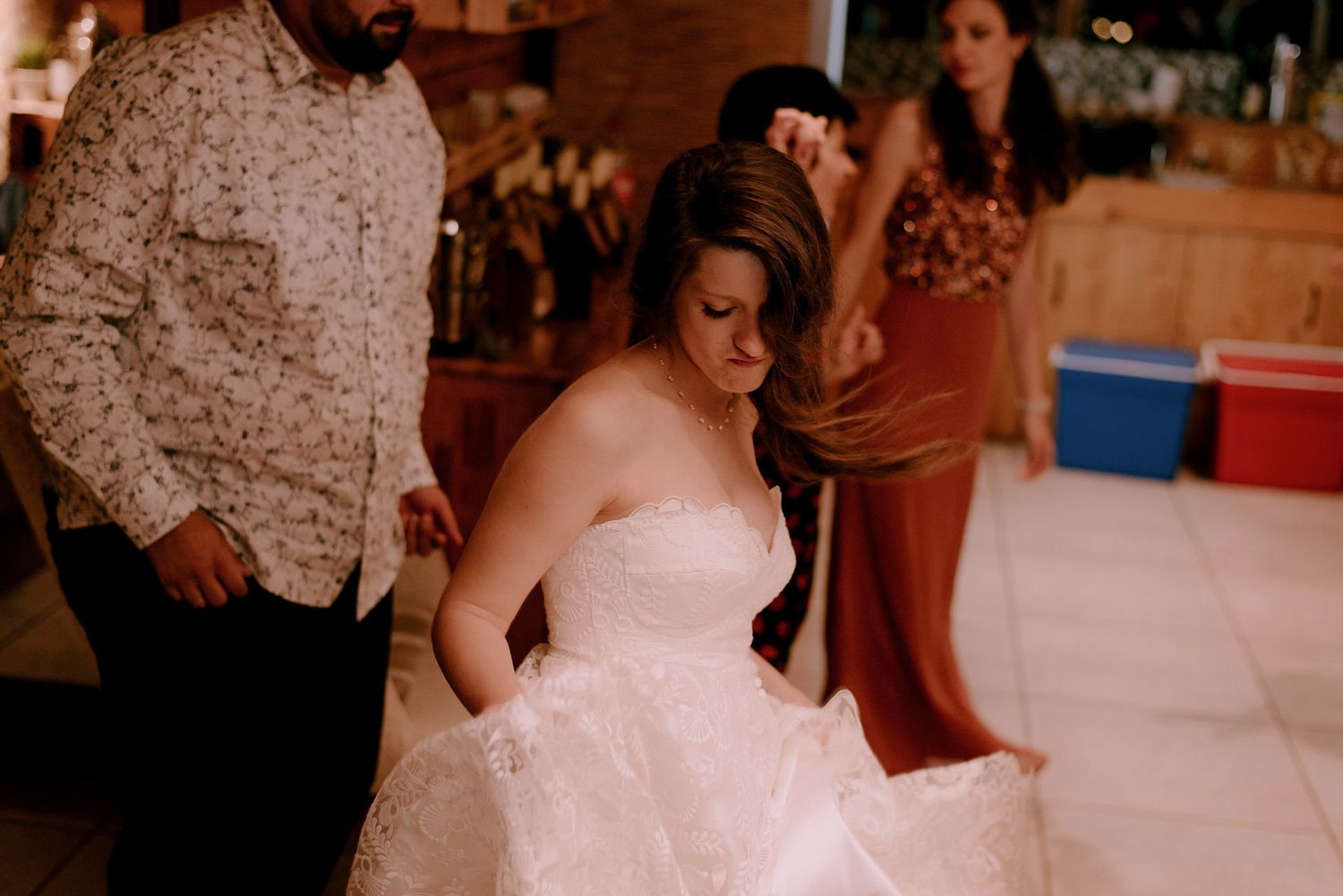 Couples dancing together on a white dance floor in a wooden-walled venue.