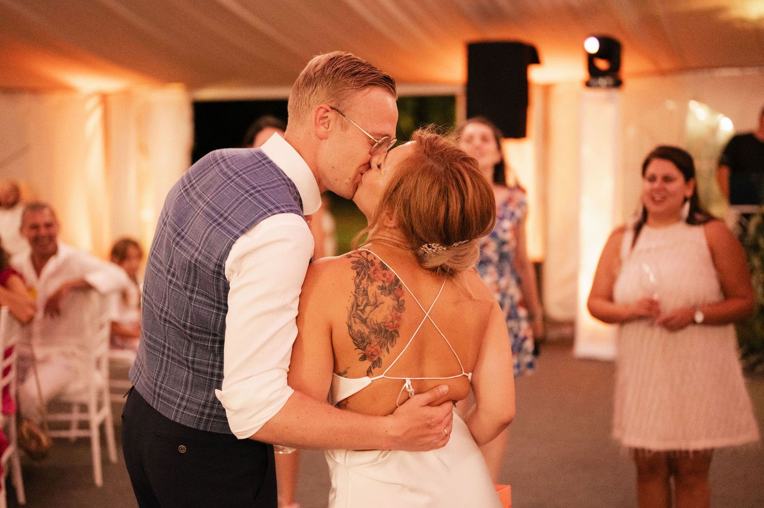 A romantic dance sequence at a wedding reception shows couples embracing on a warmly lit dance floor.