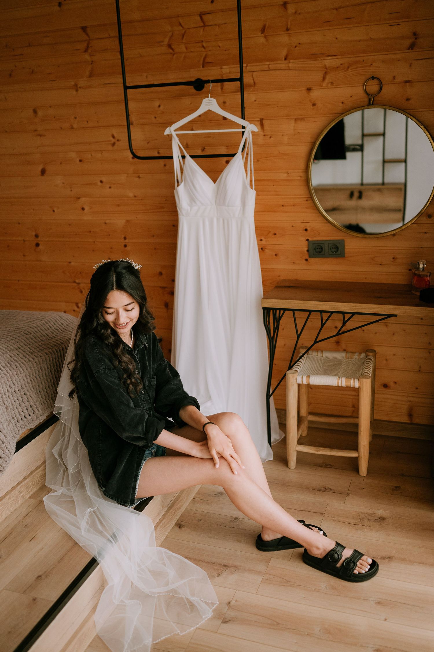 Artistic indoor portrait with black outfit contrasting against light wood and white dress.