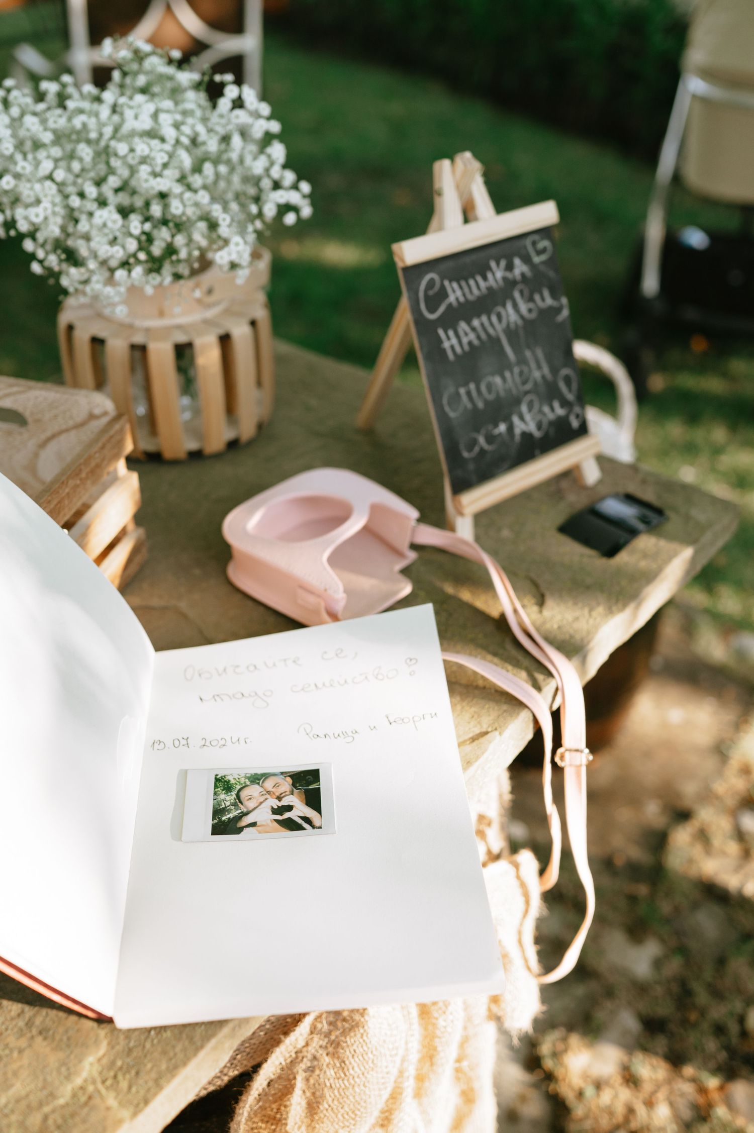 Open wedding guest book with delicate pink ribbons and baby's breath floral arrangements.