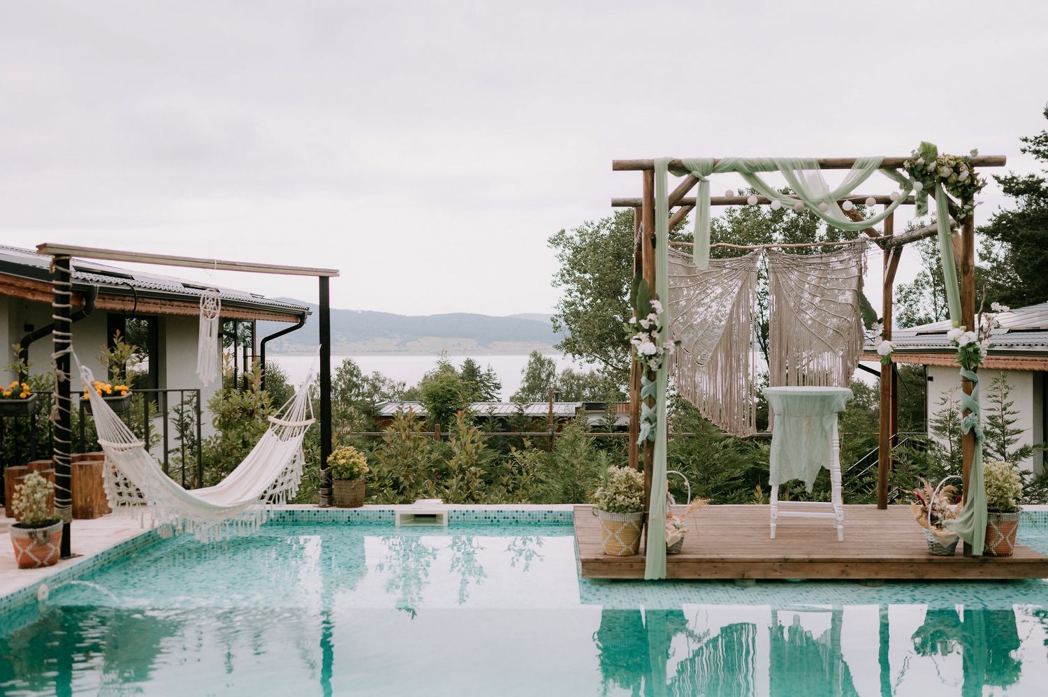 Modern poolside venue with mountain views and wooden pergolas.