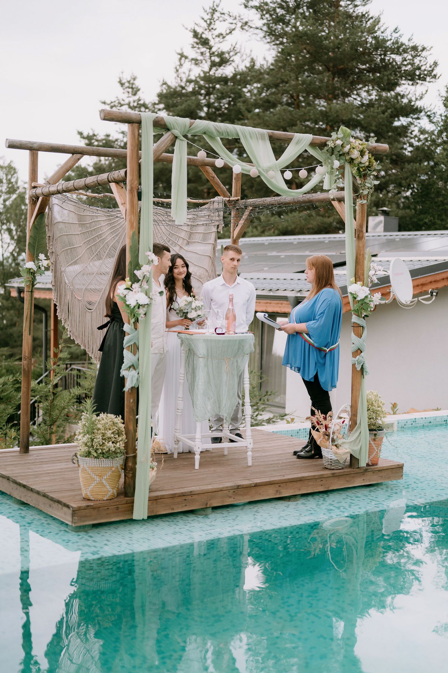 Celebration unfolding on wooden deck overlooking turquoise pool with decorative elements.
