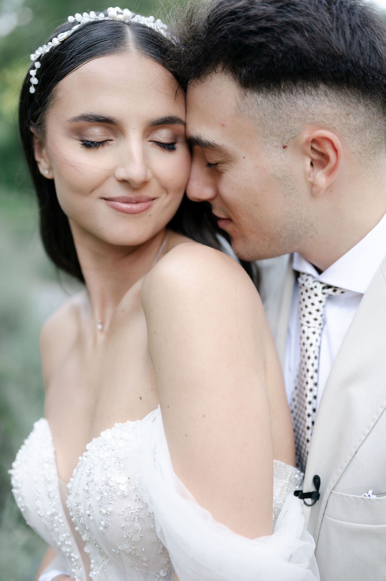 Close-up wedding portraits showing gentle intimate moments between a couple in white attire.