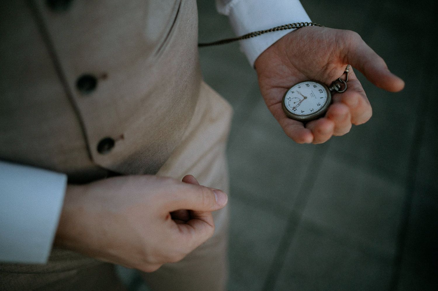 Hands holding and examining a vintage pocket watch.