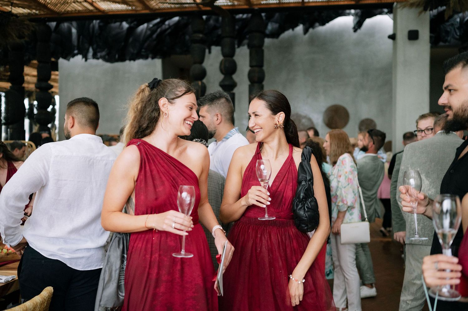 Wedding party members in burgundy dresses and formal attire gather during a reception.