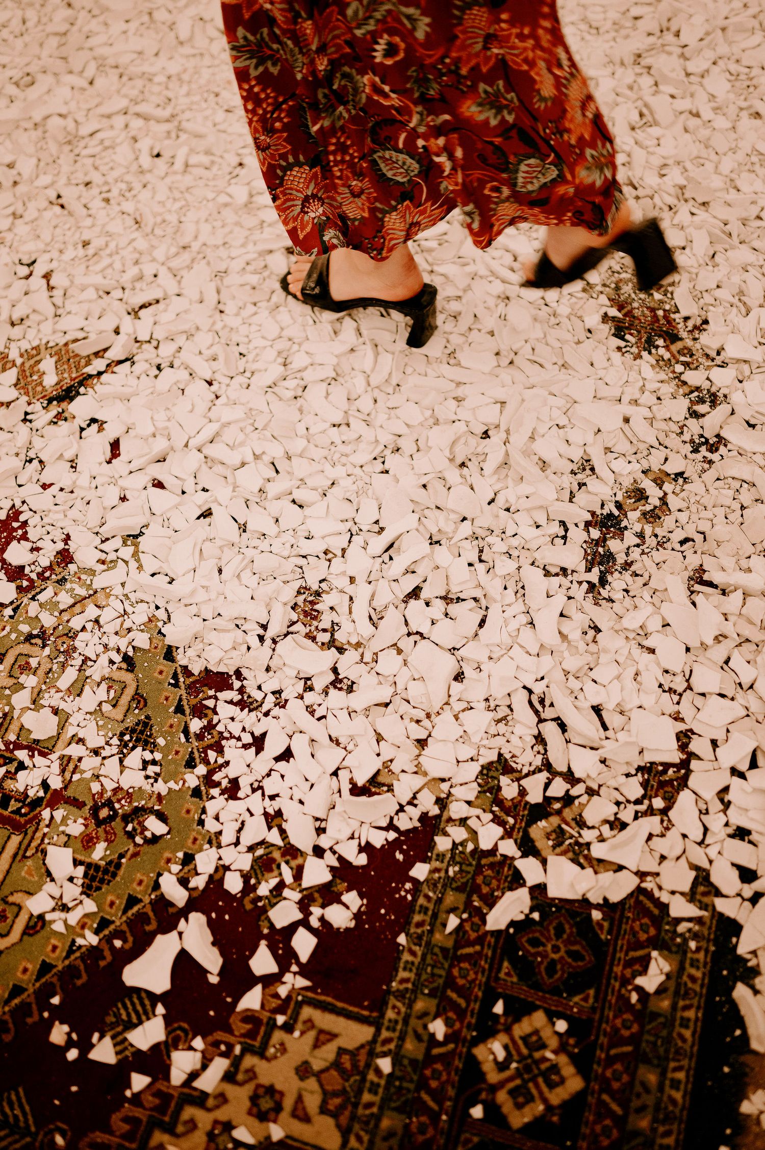 Close-up of white confetti scattered across a decorative patterned carpet.