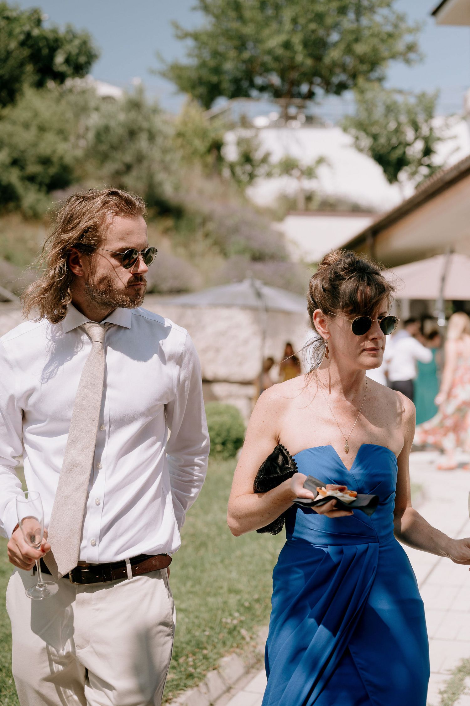 Wedding guests in blue and white attire enjoying an outdoor summer celebration.