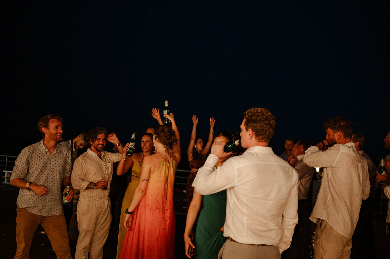Energetic dance party with guests celebrating under the night sky.