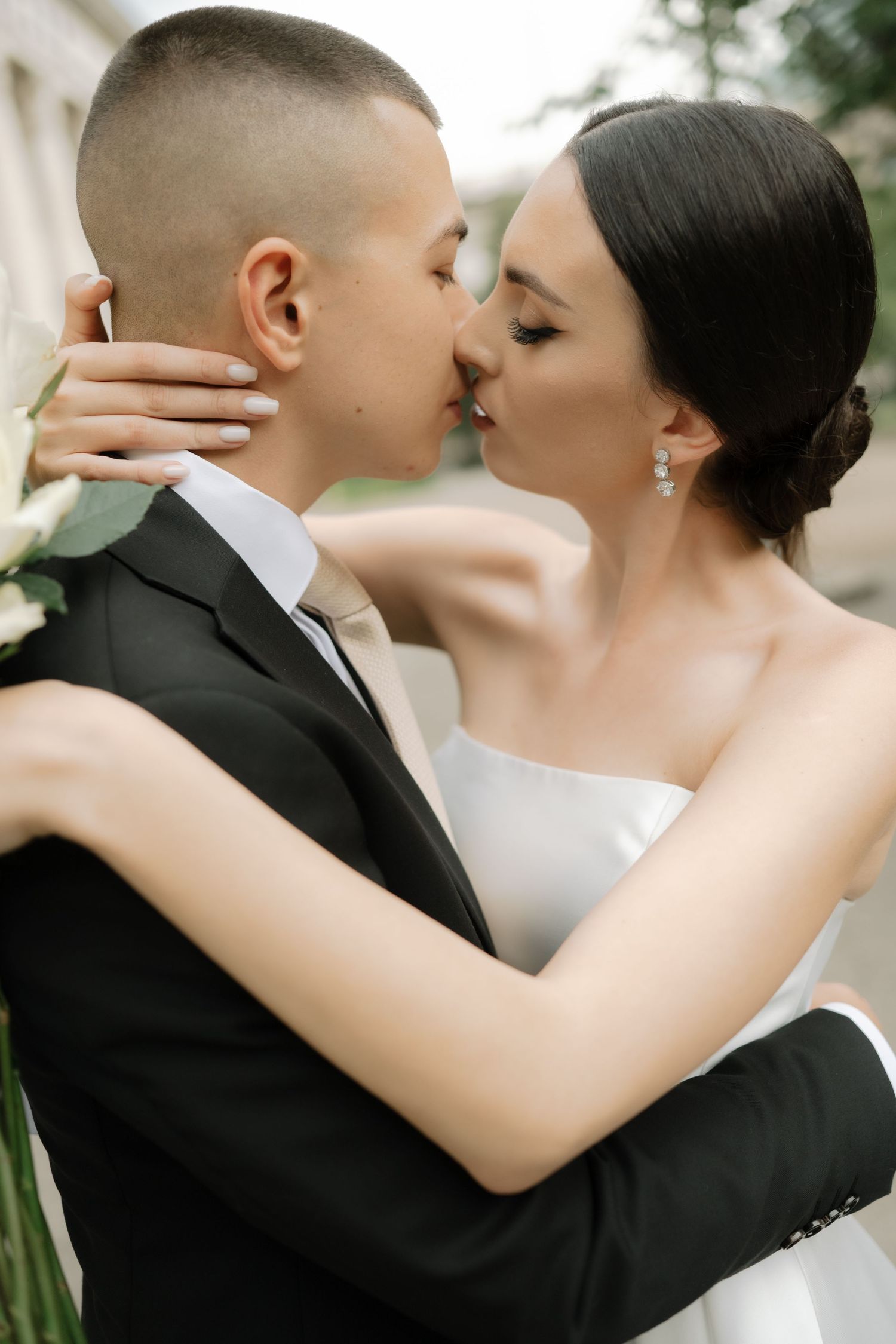 Intimate wedding portraits capture tender moments between newlyweds in black and white formal attire.