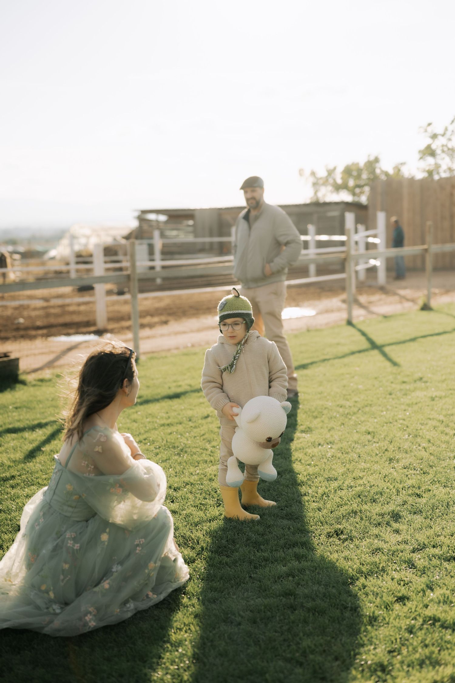 A romantic couple sits together on a grassy hillside during golden hour, creating a series of candid moments.