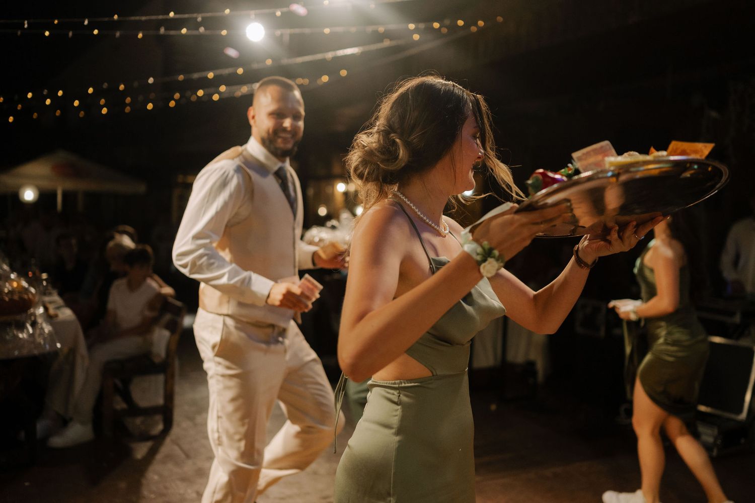 Couples dance and twirl together during a romantic evening celebration with string musicians performing live music.