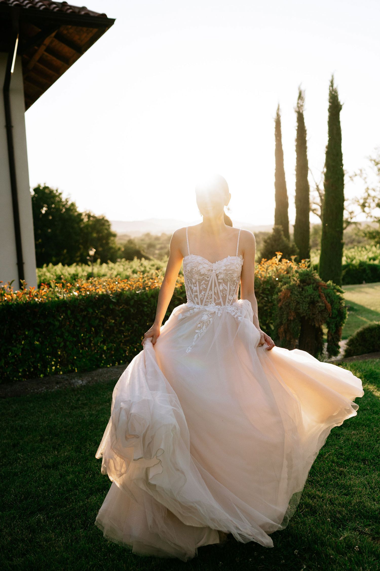 Ethereal bridal portrait showing movement of flowing white wedding dress at sunset.