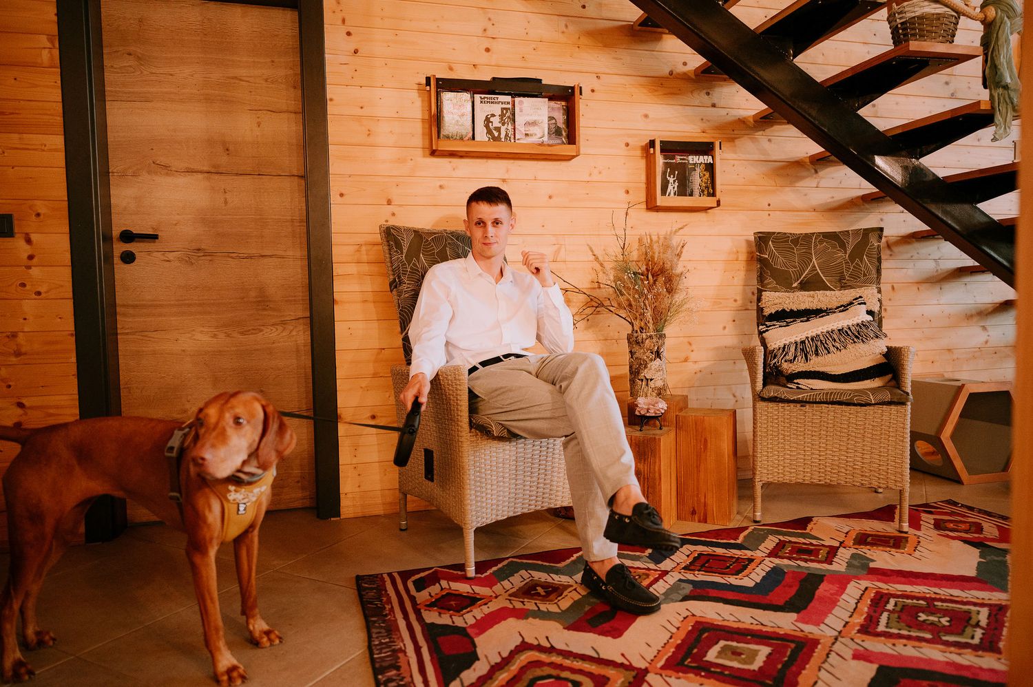 Rustic wooden cabin interior with exposed beams and patterned rugs on the floor.