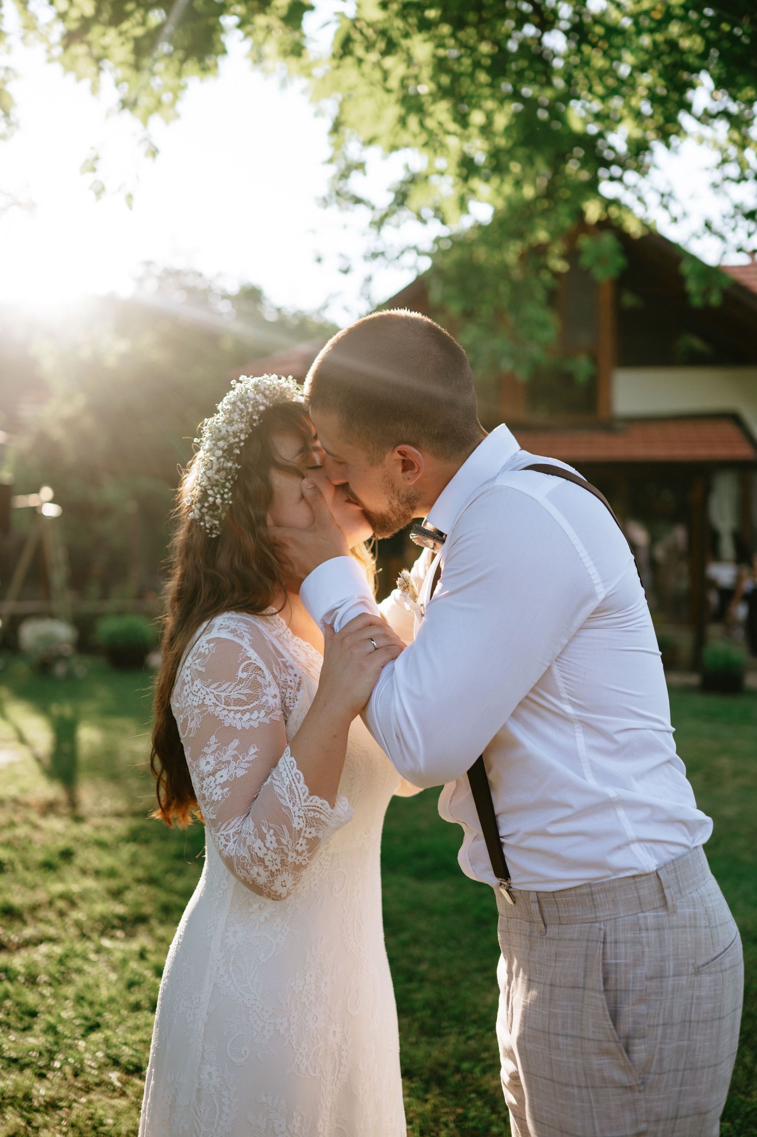 Romantic wedding couple embracing during golden hour in a garden setting.