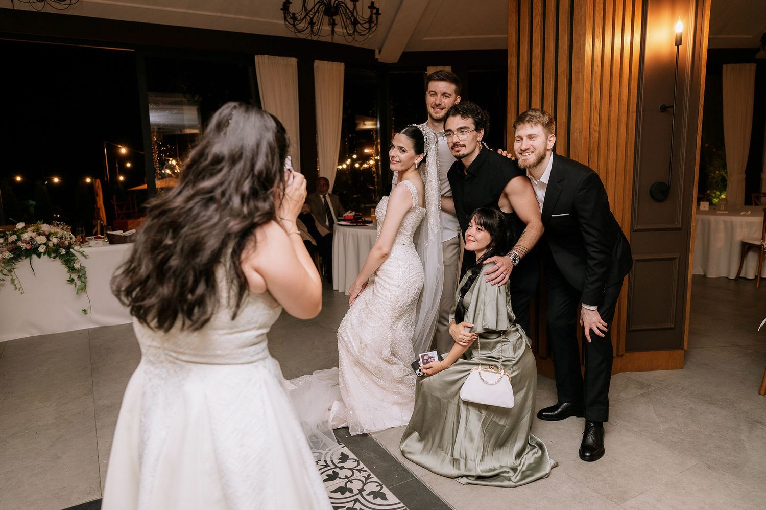 Wedding guests enjoying a lively dance party in a warm-lit reception hall.