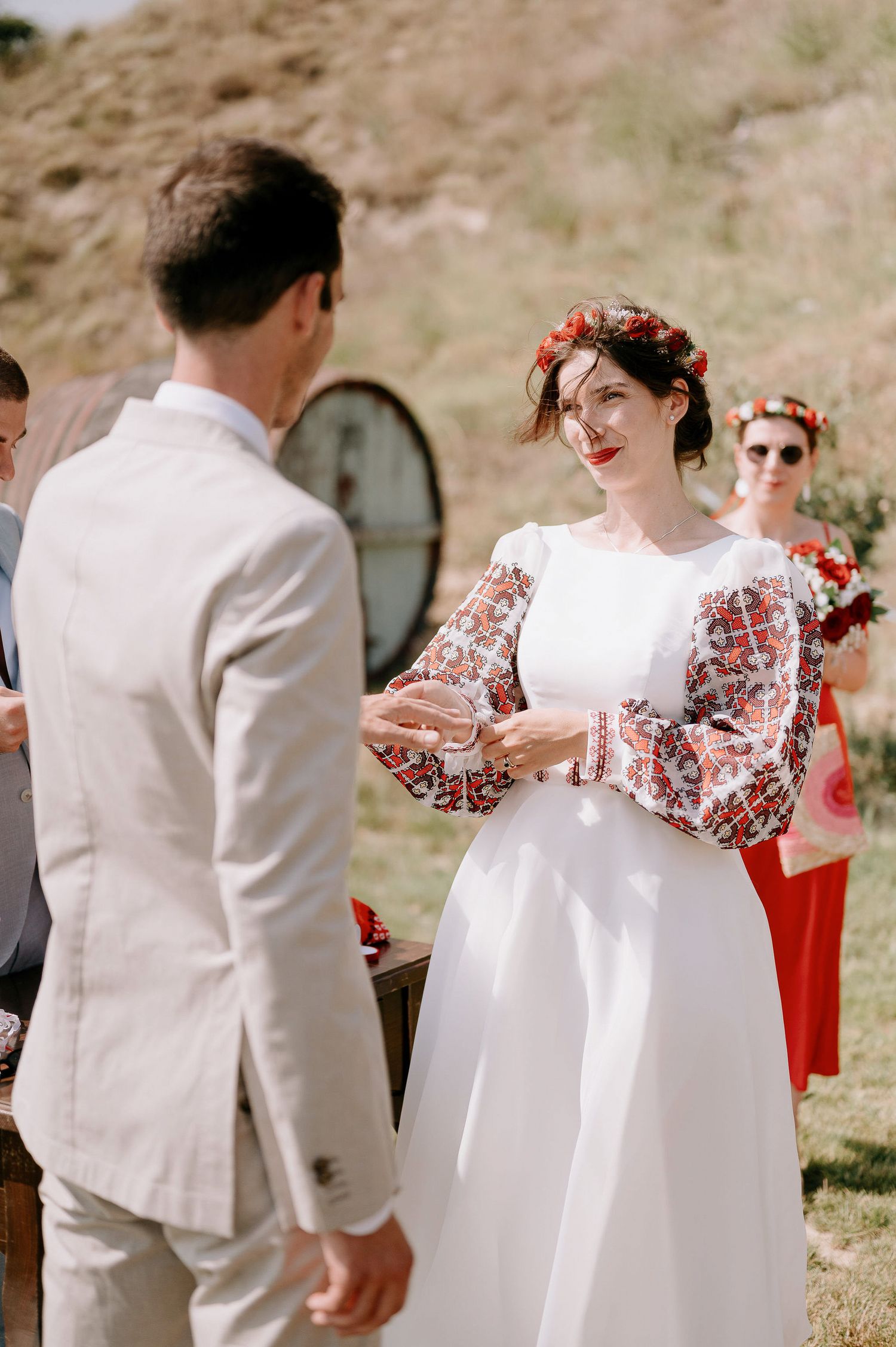 Wedding ceremony details showing white and red attire against a desert backdrop.