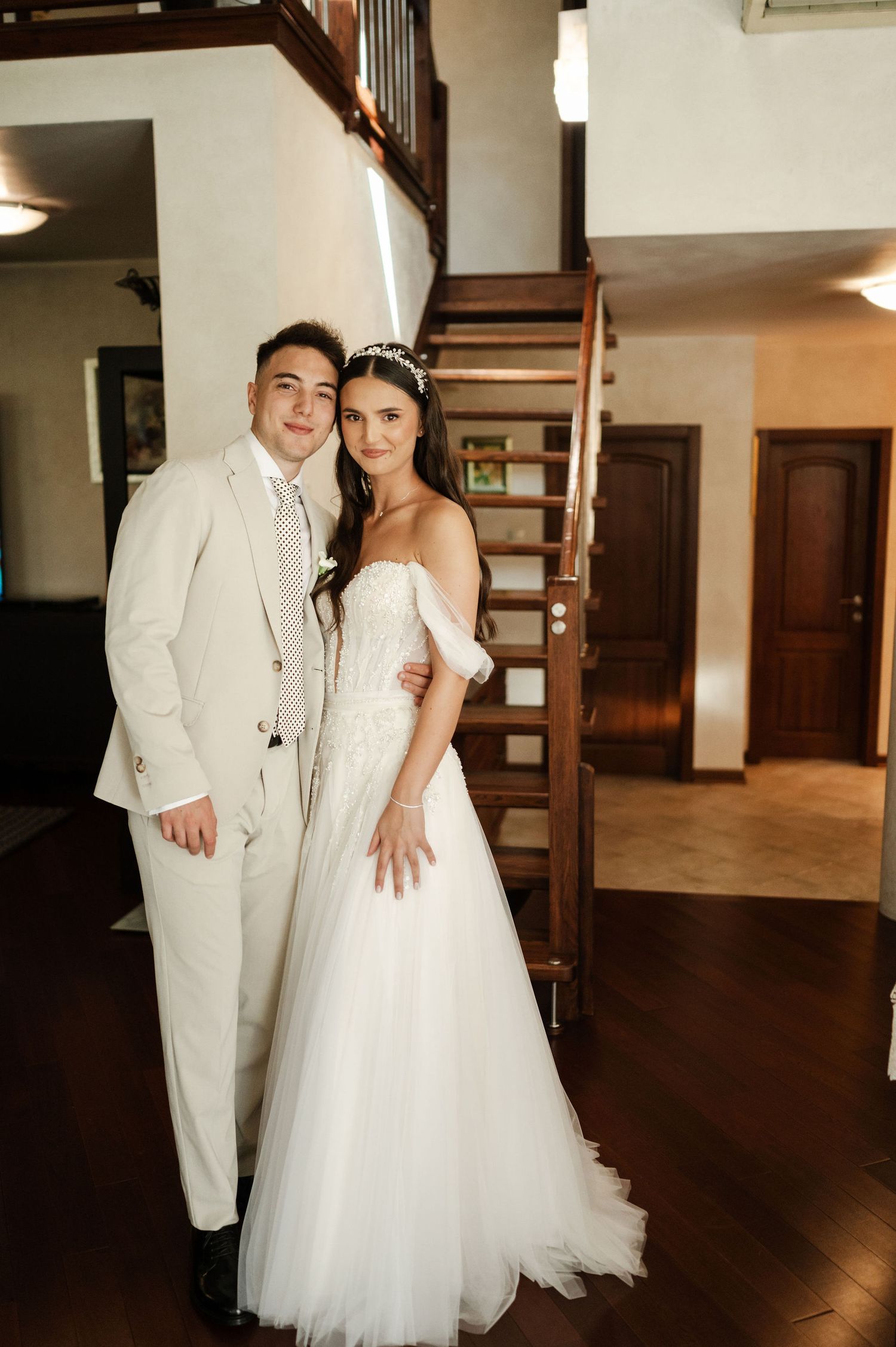 Newlyweds share joyful moments during their wedding photoshoot in an indoor venue.