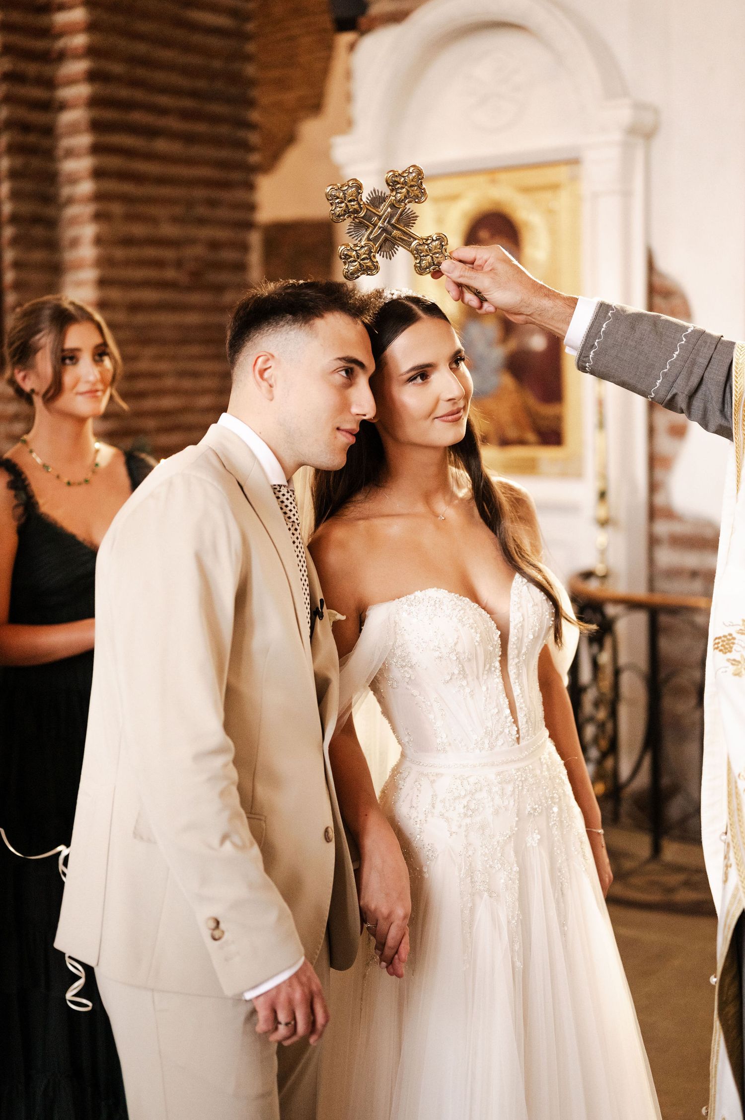 Wedding ceremony scene in a historic brick church with elegant decor and lighting.