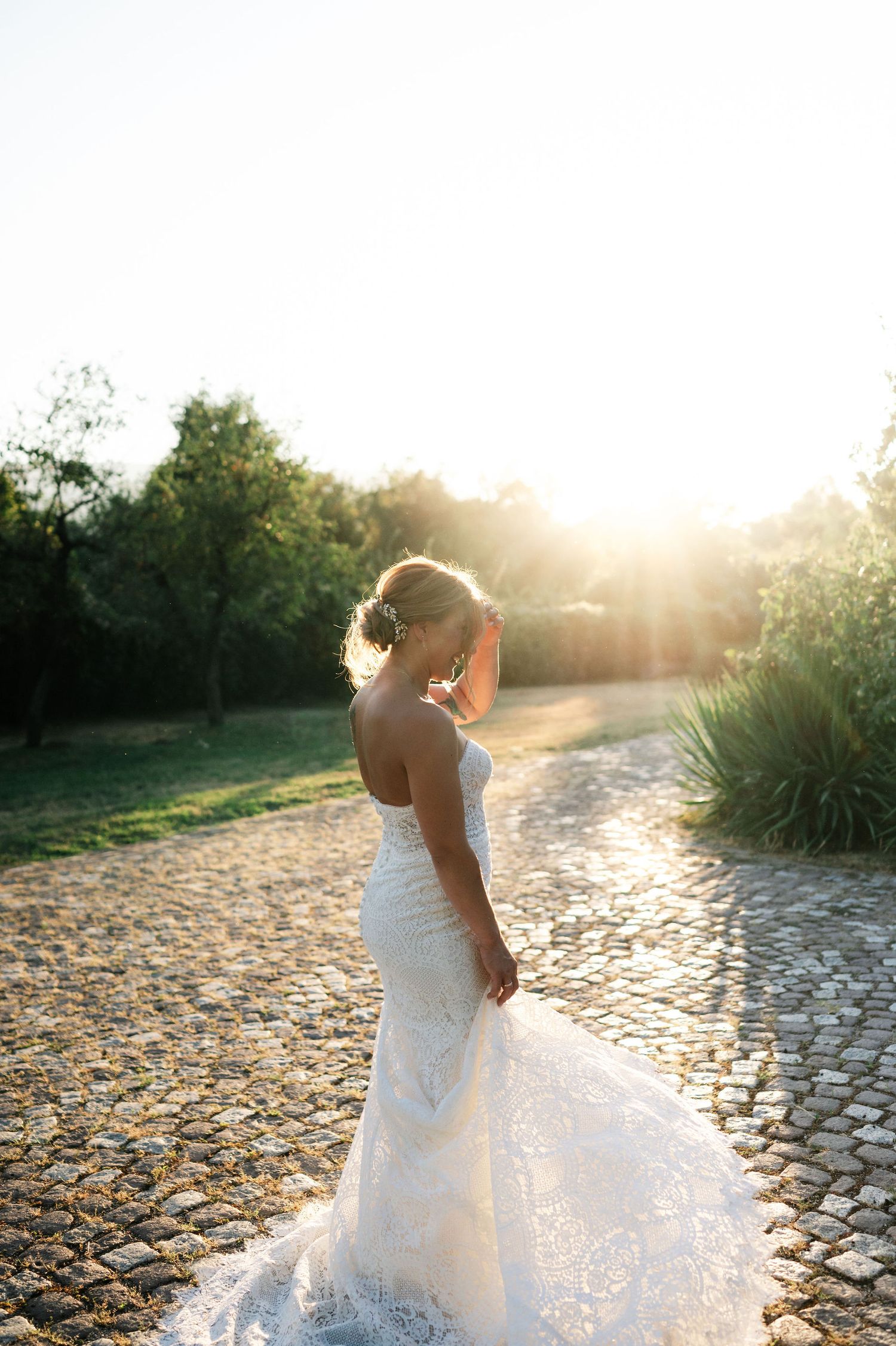 Stunning bridal portrait with flowing dress captured in magical sunset lighting.