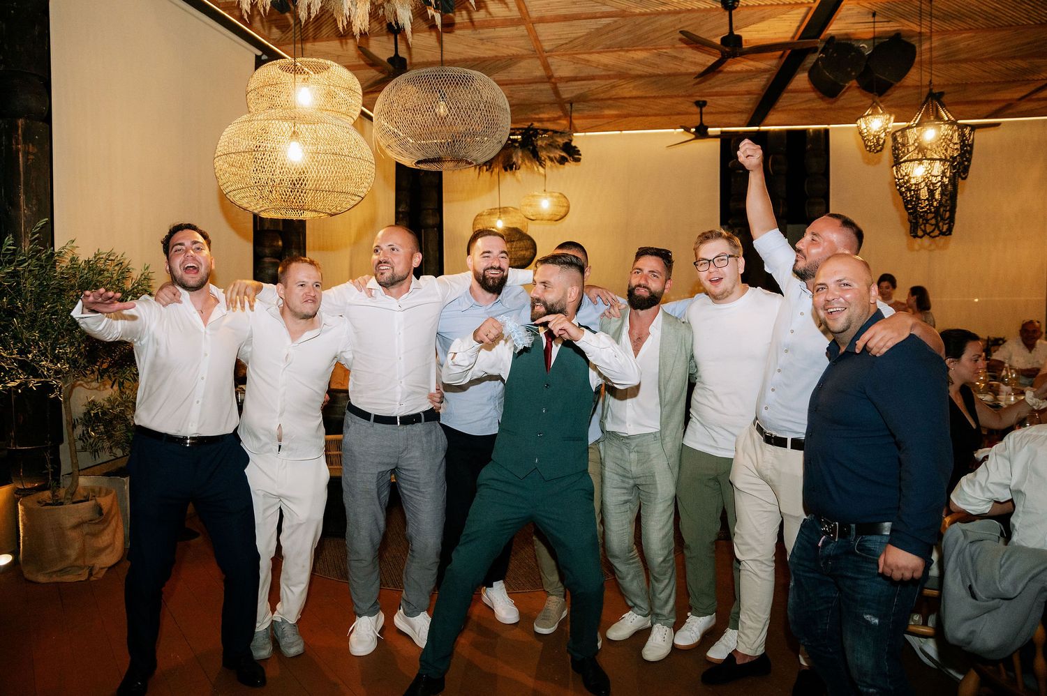 Groomsmen in coordinated outfits posing together at a wedding celebration.