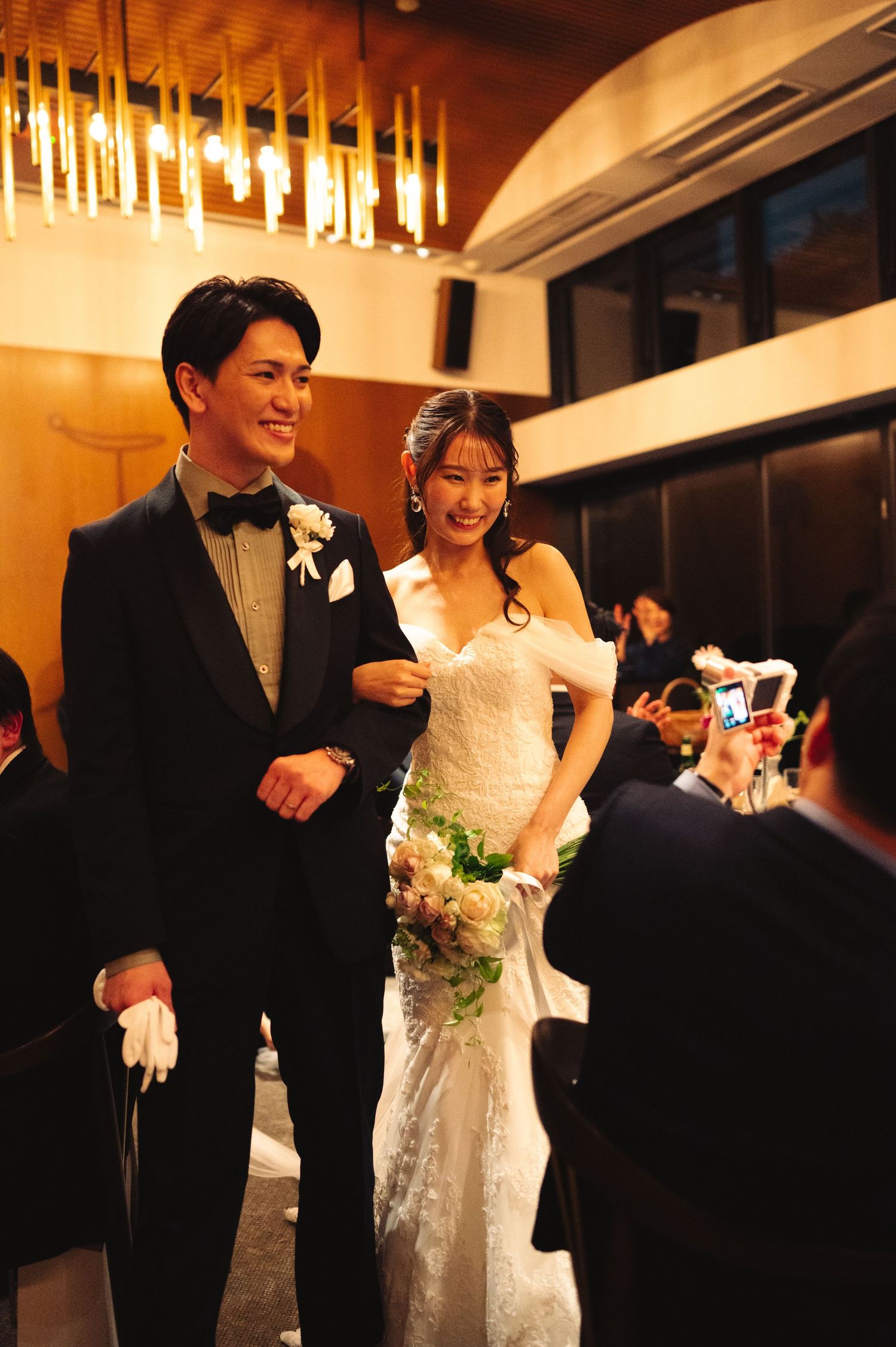 Newlyweds share joyful moments during their reception under warm lighting and modern decor.