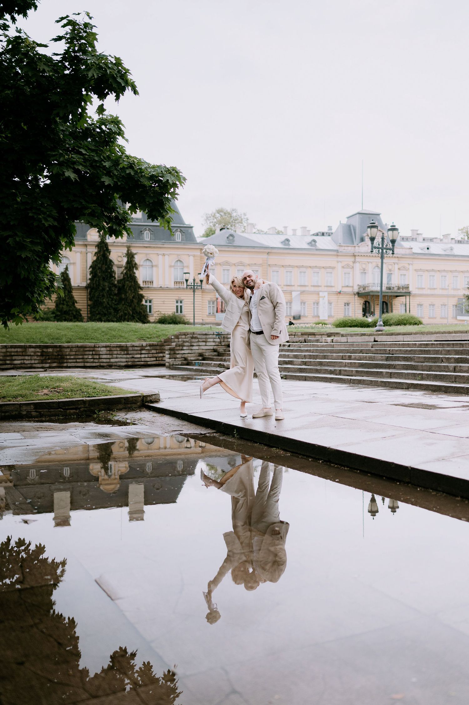 Artistic dance performance captured at palace grounds with water reflection and stone steps.
