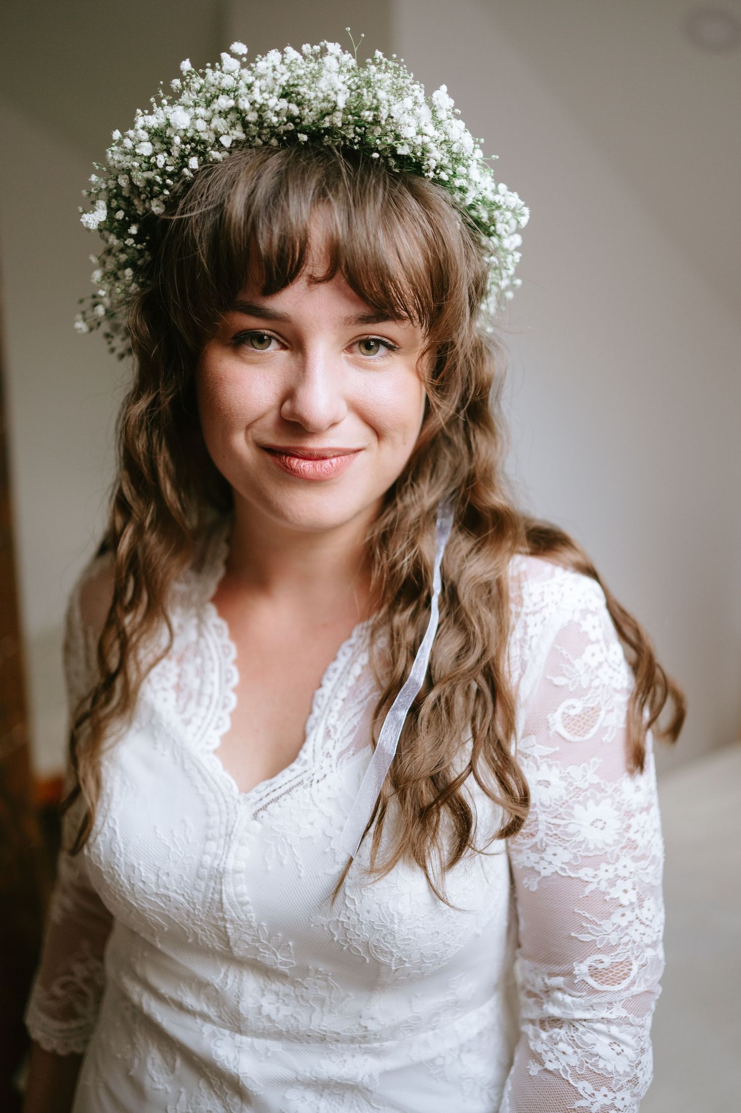 Delicate baby's breath crown adorns a white lace wedding dress.