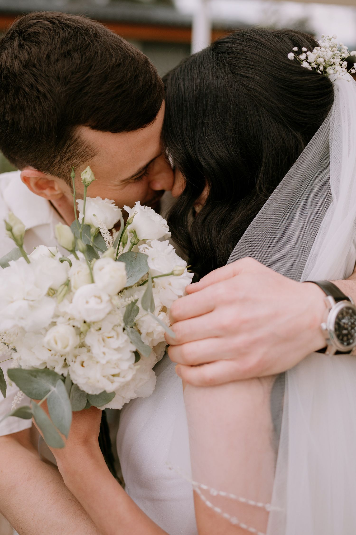 Tender wedding moments with white roses and eucalyptus bouquet details.